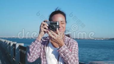 美丽的女人在河岸和微笑的复古摄影镜头上拍照